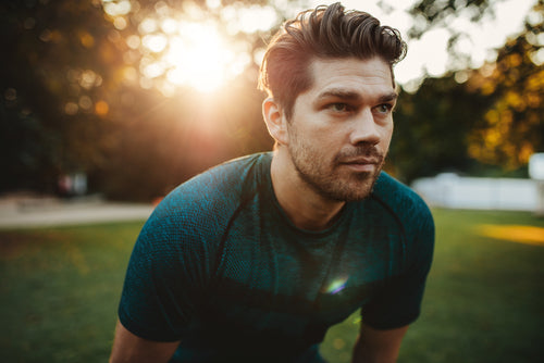 closeup of man standing hunched in park