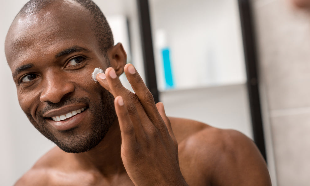 man applying facial lotion