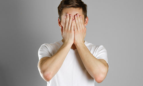 man covering face with hands