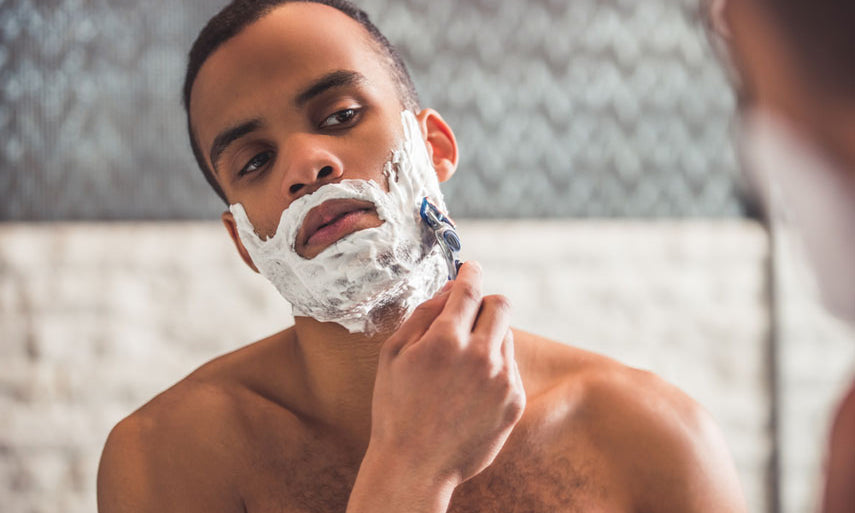 man shaving with razor and cream