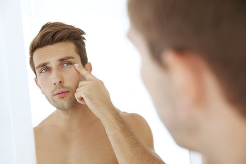 man checking face in mirror