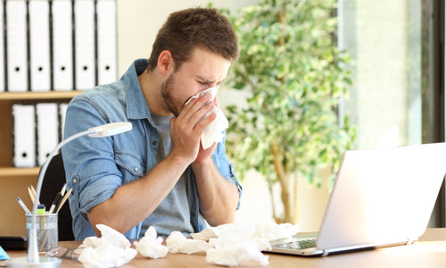 man with cold at desk