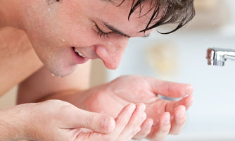 man splashing water on face