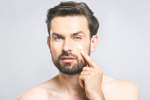 man applying eye cream